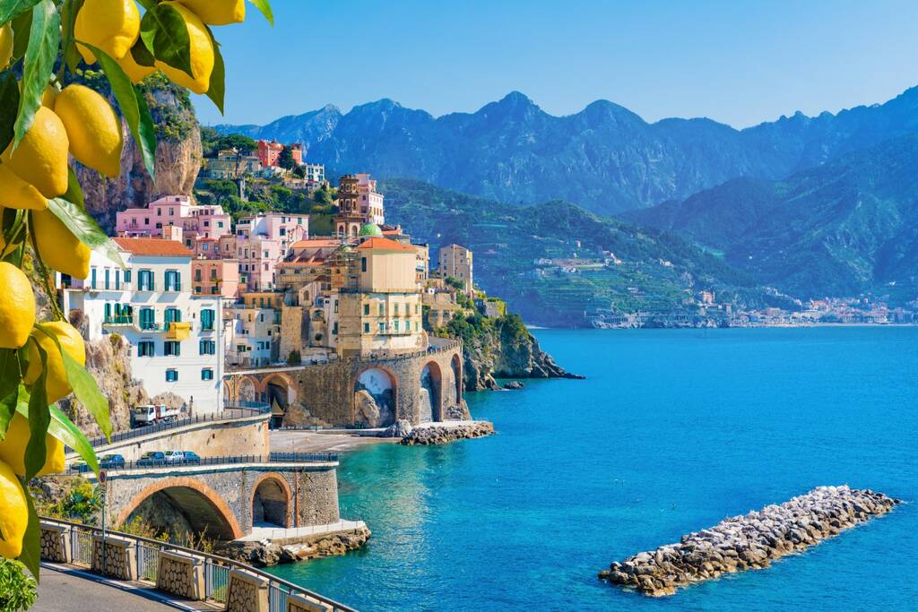 Małe miasteczko Atrani na wybrzeżu Amalfi w prowincji Salerno, region Kampania, Włochy. Wybrzeże Amalfi na Zatoce Salerno jest popularnym miejscem podróży i świętego miejsca we Włoszech. Dojrzałe żółte cytryny na pierwszym planie.