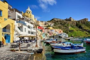 Procida island, Naples, Italy, colorful houses, fishermen boats and cafes on the seaside in Marina di Corricella harbor
