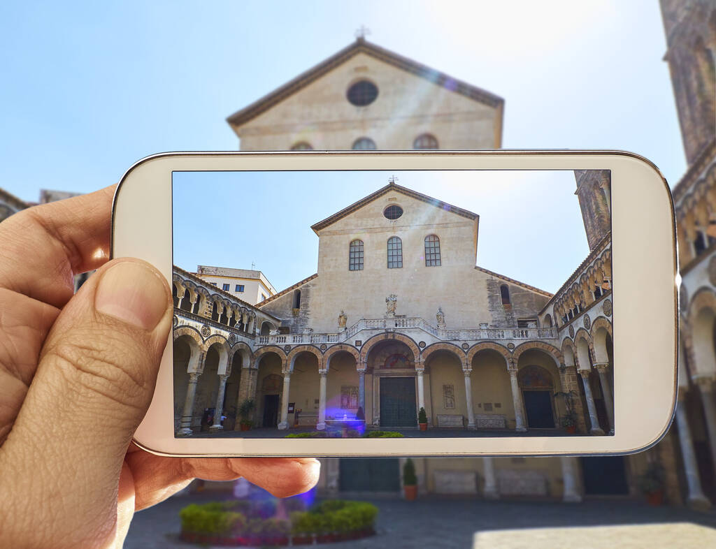 Male hands taking a photo of principal facade of the Cattedrale di Salerno Cathedral in Duomo di Salerno. Campania, Italy.