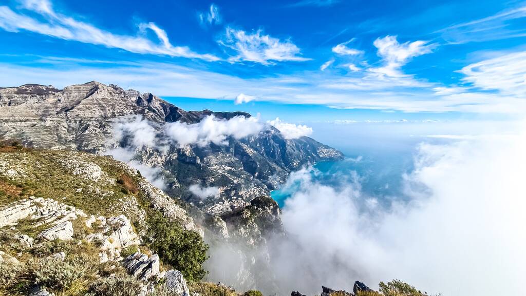 Scenic view from Monte Comune on cloud covered peaks Monte Molare, Canino, Caldare, Lattari Mountains, Apennines, Amalfi Coast, Italy, Europe. Hiking trail to coastal town Positano, Mediterranean sea