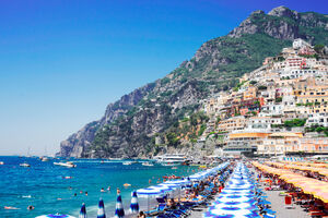 Thyrenian Sea and row of bright umbrellas on beach of Positano - famous old italian resort, Italy
