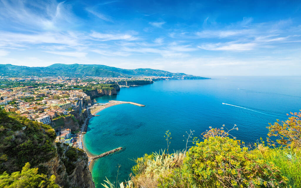 Aerial wide angle view of cliff coastline Sorrento and Gulf of Naples, Italy. Clear azure sea and luxury hotels of Sorrento attract lot of tourists from all over world.  