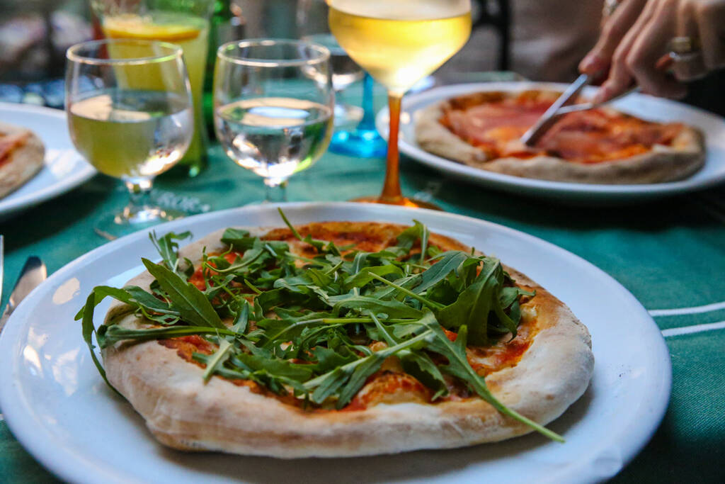 Sorrento, Italy - July 15 2017: Pizza with arugula on a white plate in Sorrento Italy
