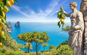 Witamy na Capri. Kolaż ze słynnymi skałami Faraglioni w lazurowym morzu i posągiem cesarza Augusta trzymającego w ręku kiść świeżych żółtych dojrzałych cytryn, wyspa Capri, Włochy., licencja: shutterstock/By IgorZh