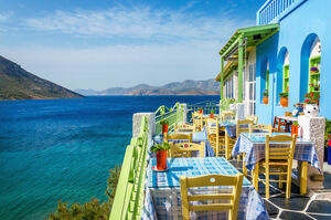 Typical Greek restaurant on the balcony blue building overlooking the sea, Greece