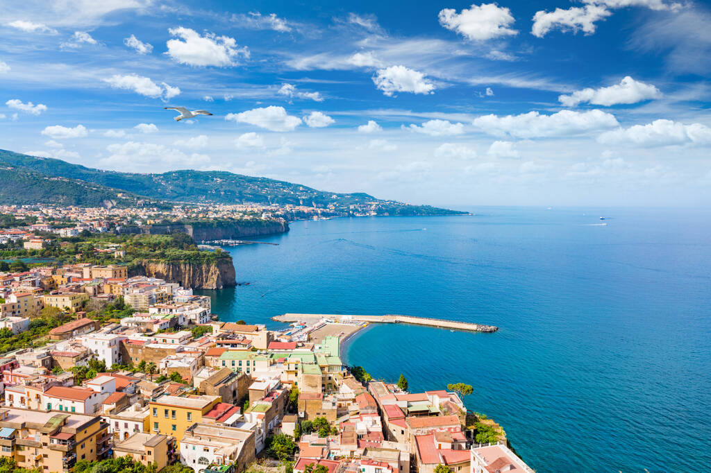 Aerial view of coastline Sorrento city and Gulf of Naples - popular tourist destination in Italy. Sunny summer day with blue sky, clear sea and green mountains of Sorrento  peninsula.