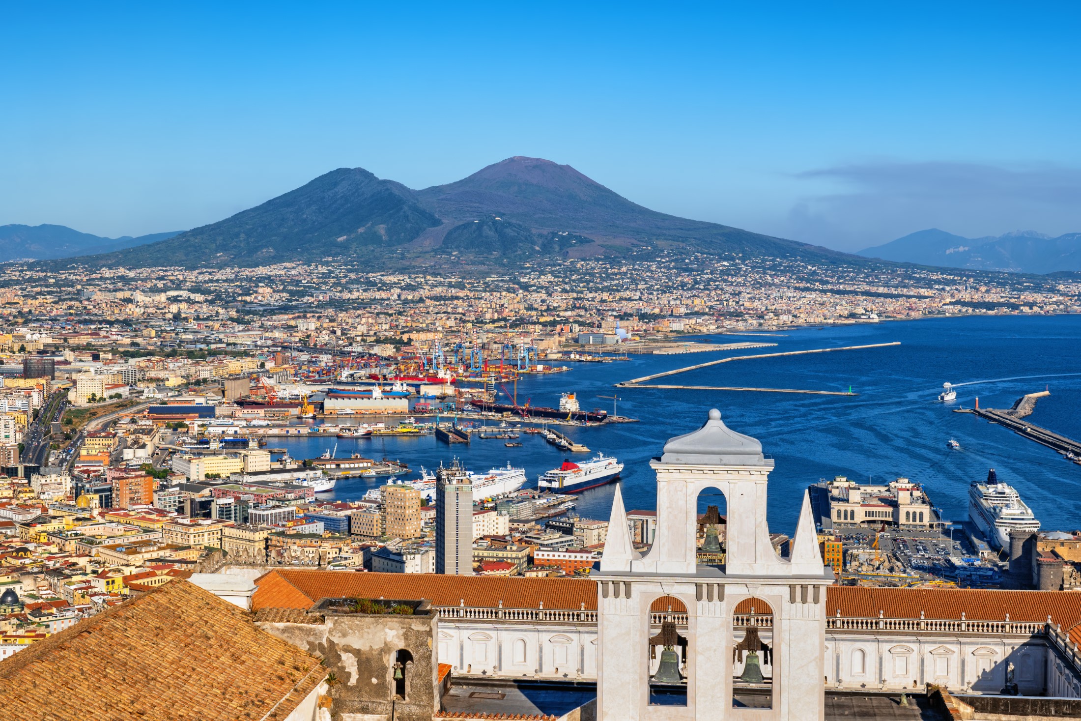 City of Naples in Italy, cityscape with port and Gulf of Napoli with mount Vesiuvius on the horizon, Campania region.