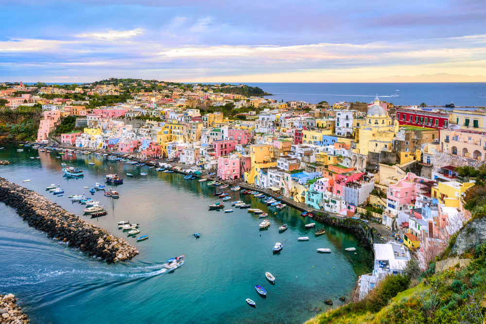 Procida island, Naples, Italy, colorful houses in Marina di Corricella harbour in dramatic sunrise light