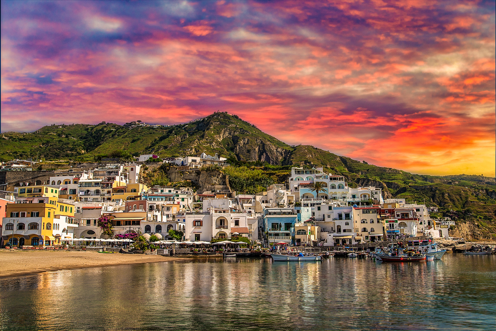 sunset on higgledy-piggledy piled houses on bay of Ischia island, Naples in Italy