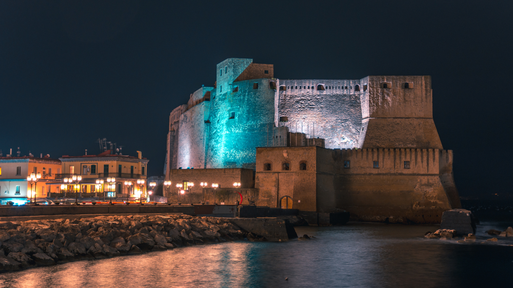 Night picture of an old castle by the sea in the city of Naples, Italy
