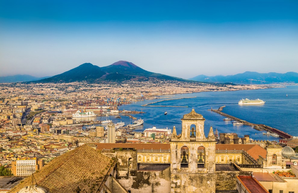 Zatoka Neapolitańska, Scenic picture-postcard view of the city of Napoli (Naples) with famous Mount Vesuvius in the background in golden evening light at sunset, Campania, Italy